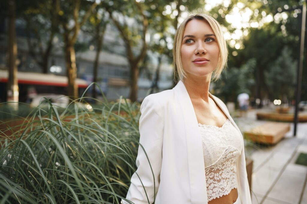 Portrait of beautiful smiling female in stylish office clothes in city